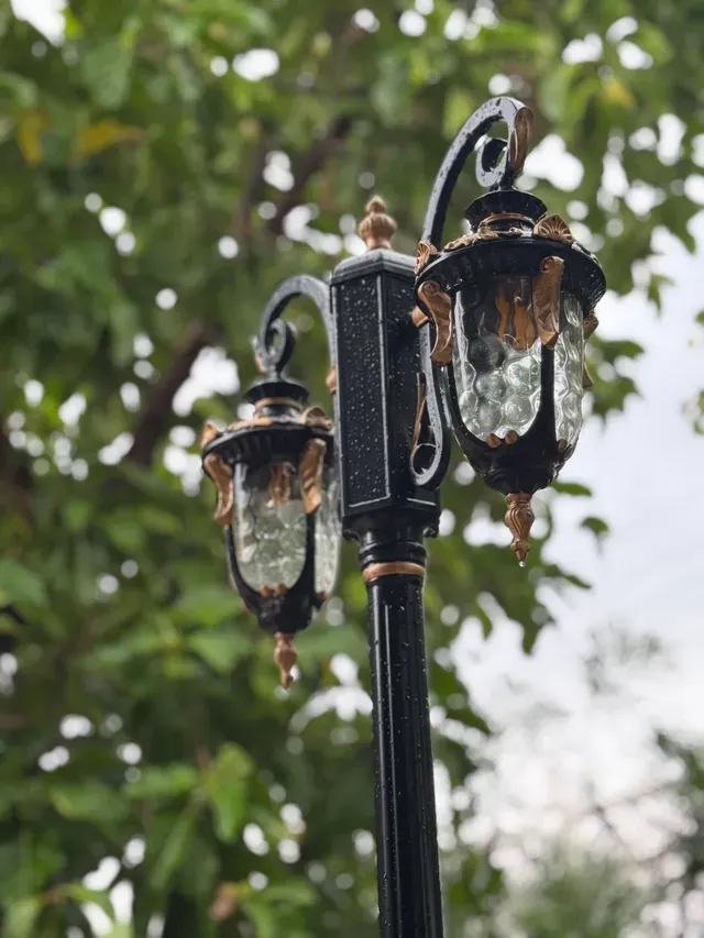 Farol de hierro forjado entre el follaje del jardín