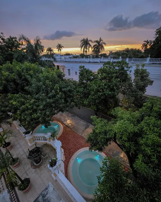 Vista aérea al atardecer de los dos jacuzzis circulares entre los árboles del jardín
