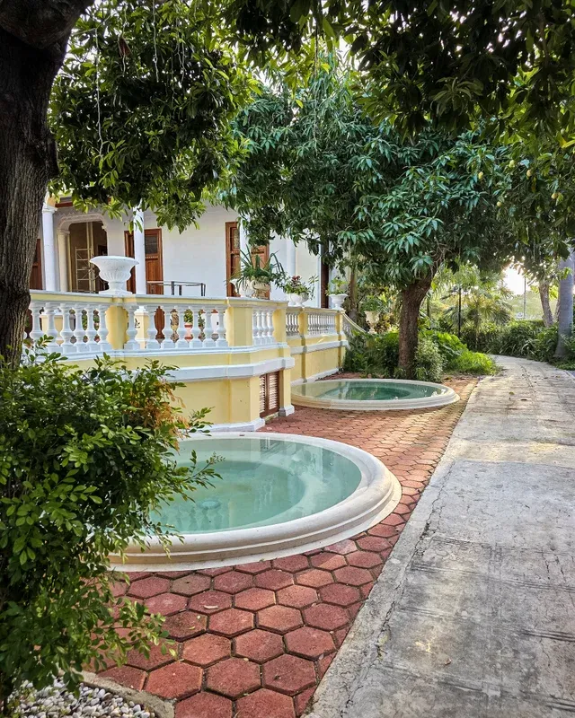 Los dos jacuzzis circulares del jardín, entre árboles y la balaustrada de la casa