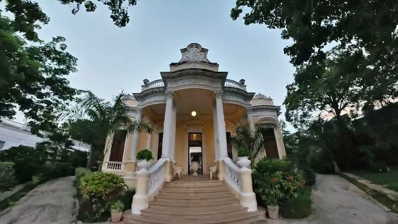 Fachada amarilla de Casona Cicero con sus columnas blancas, vista desde el acceso principal